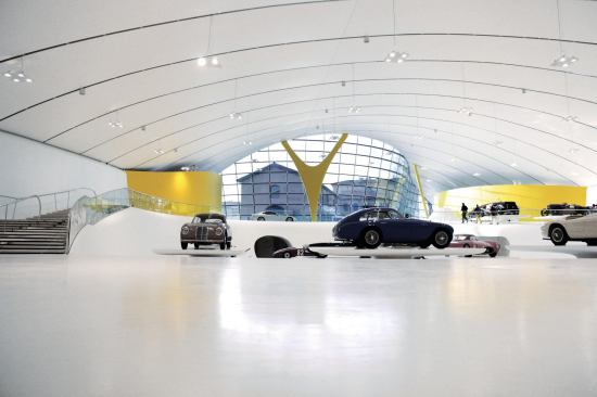 Inside, the ceiling plane is far less brightly hued that the vivid exterior: White PVC fabric is stretched taut over web trusses, akin to the ceiling of a car.