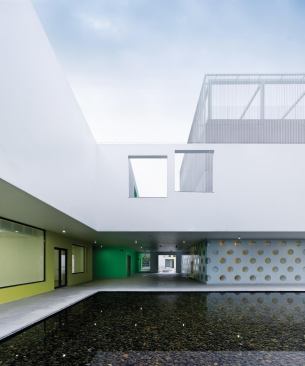 A courtyard with a large reflecting pool serves as a hub for several of the building volumes, such as a theater and dance studios.