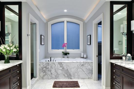 A simple, elegant marble-clad master bathroom.