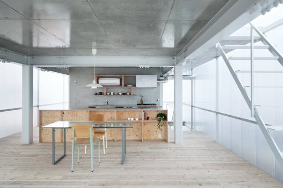 The open kitchen, dining, and living area takes up the majority of the second floor. While views out are obstructed by the translucent walls, the windows can be opened for more direct light and views.