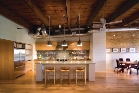 A kitchen assembled largely from stock cabinets offers a modernist counterpoint to the loft’s 19th-century industrial shell. 