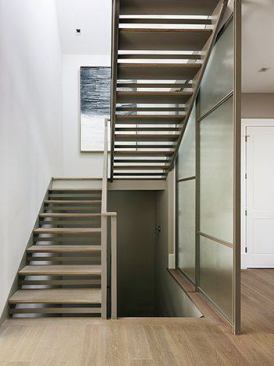 One of the first things people see upon entering is a glass partition and main floor stairwell. “It lets you know you’re not in Grandma’s Victorian,” Feldman says. Built on site in the basement, the stairs pull in light from skylights above. Juxtaposed next to wood paneling, wainscoting, and other wood work, “the floor-to-ceiling screen floor draws you in and peaks your interest.”