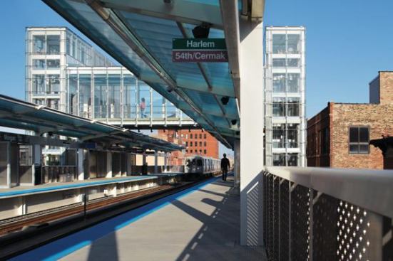 The station’s two elevated platforms are connected by a pedestrian bridge. Polycarbonate-and-painted-steel canopies provide shelter from the elements for those waiting for their trains.