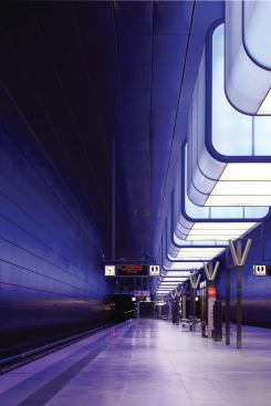 Raupach Architekten and Pfarré Lighting Design drew inspiration from Hamburg’s architectural features and function as a port city in their design of the new HafenCity University subway station. Gunmetal steel panels line the station walls recalling the patina of a ship’s hull. This, in concert with the light emitted from the 12 light boxes suspended over the subway platform, recalls the shimmering effect of water, and is a nod to the harbor above.