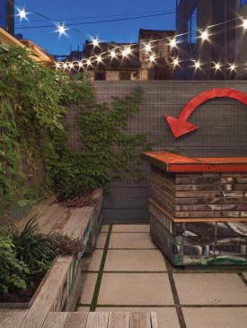 The Urban Garden transforms a home's lackluster backyard into a landscaped patio complete with a red, reclaimed-metal bartop by Gatski Metal. 