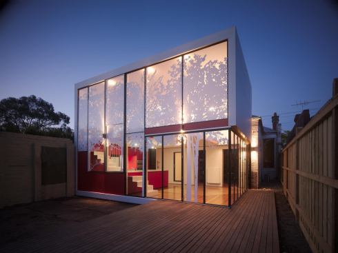 The Tattoo House’s two-story addition meets local design requirements for 70 percent opacity on second-story windows by using oversized UV-resistant stickers created from photos taken at a nearby park.