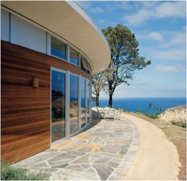 As with many of the firm’s houses, the quiet front elevation of this La Jolla, Calif., residence (below, left) gives way to a dramatic rear façade (left and below). Clerestory windows let sunlight spill into the interiors.