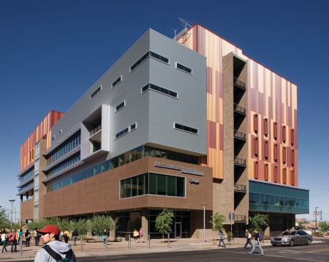 The colored metal of the façade is broken up by smooth aluminum composite panels, glazing, and masonry, all of which are arranged in response to the building's program. Light is allowed to penetrate the façade into classrooms, meeting spaces, and computer labs, but broadcasting studios and other light-sensitive areas are concealed behind the opaque surfaces. EXTERIOR PANELS - Alucobond Aluminum composite flat panel system - alucobond.com - GLAZING - Oldcastle Glass - Exterior glazing - oldcastle.com - SIGNAGE - Fluoresco Lighting and Signs - Exterior signage - fluoresco.com