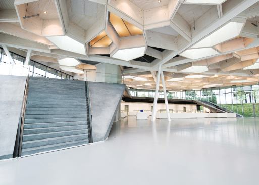 Each cell in the honeycomb ceiling of Barkow Leibinger's restaurant and event space is dedicated to a specific purpose, such as lighting or acoustics. Cells that incorportate luminaires are wired on different circuits, so that all the lights don't have to be turned on at once. Tubular speakers hang from some cells to distribute sound through the space during lectures, meetings, and concerts.