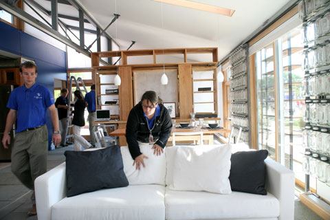 Penn State's home had various glazing effects on the south-facing wall (shown) such as a sliding milk bottle wall to help spread light into the space and block heat, and white oak exterior sliding panels to provide shading from direct sun and privacy.