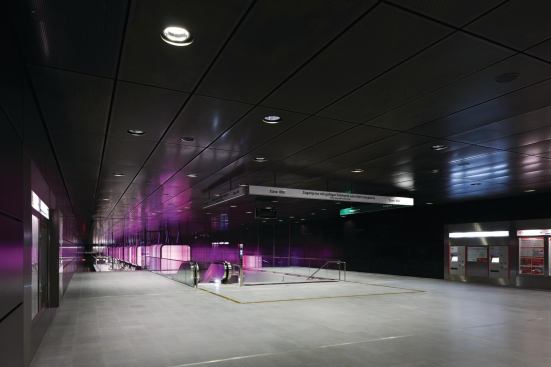 Metal halide downlights provide illumination at the ticket vending machines.
