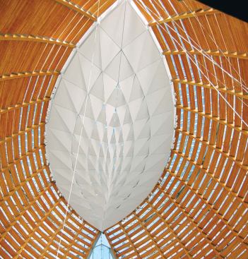 Above the sanctuary hovers an oculus with a scrim of faceted acoustical panels. The panels help absorb sound in the cavernous interior and filter daylight from the skylight above.