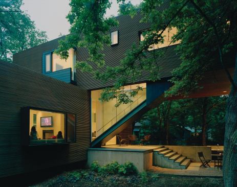 A rainscreen cladding of Brazilian redwood provides a textural contrast with the glass-enclosed staircase.