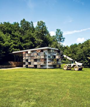 Pallets of landscaping materials create a mosaic of natural textures on the side of a storage barn in western Connecticut, enhancing the design of the compact structure while cleaning up the previously littered site.