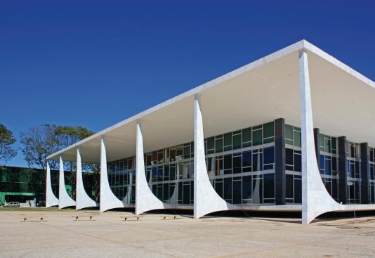 Niemeyer was lain in state at the Palácio do Planalto, which he designed in 1960 as the official workplace for the president of Brazil. The inverted parabolic arches running transversely to the building's body serve as columns, a variation on the arches that Niemeyer designed for the Palácio da Alvorada, the presidential residence. There, his inverted arches run parallel to the building.
