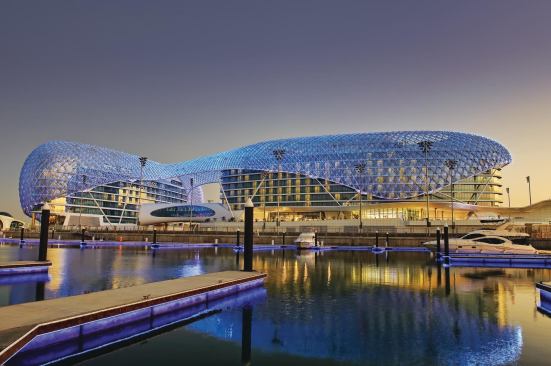 The Yas Hotel's grid shell comes alive at night, thanks to 5,800 programmable LED luminaires, one at each vertex of the latticework. The structure has an equal number of glass panels, each unique in size, shape, and angle of tilt. Frits in the panels reflect the LED light outward without affecting hotel occupants' visibility.