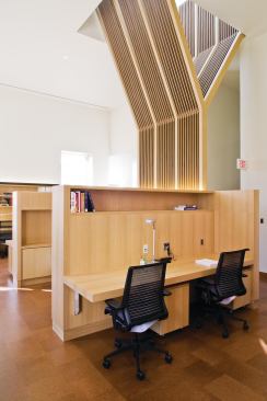 On the second floor, the screen doubles as a sunshade and a spatial divider between a reading room and the circulation pathways.