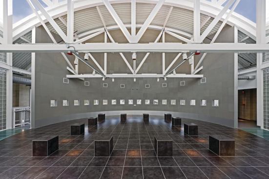 Inside the Hall of Reflection, ceramic tile covers the floor and the 12 benches that represent the 12 tribes of Israel. Acoustic material lines the gray wall, diffusing sound in a room otherwise composed of hard and potentially reverberant surfaces.