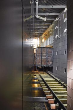 The bridge between the two volumes is an early 20th century German railcar, like those used to transport Jews to concentration camps during World War II. Visitors first see the car as they approach the Deportation space, a round room at the base of the Room of Remembrance cylinder, where they watch videos of the transportation process. After exiting Deportation, they can choose to enter the car before moving into the North Gallery in the lighter building volume.