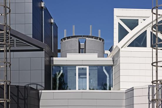 A cylindrical volume that houses the Book of Reflection is situated at the connecting point between the dark and light volumes of the museum. The cylinder punches through the roof plane and is topped by six riveted steel spires, called Points of Light, that represent the 6 million Jews who were killed in the Holocaust.