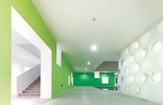 Color is introduced to the interior primarily through vivid walls that are coated in Dulux paint. The internal hallways feature self-leveling concrete floors.