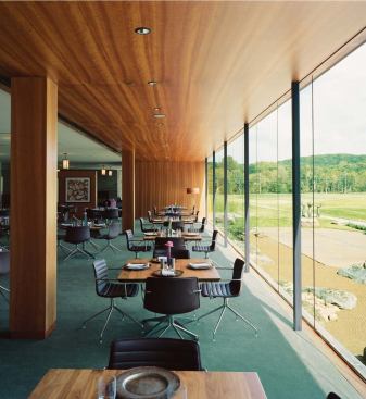 The first-floor dining room features expansive surfaces of cherry wood. Floor-to-ceiling windows overlook a Zen garden.