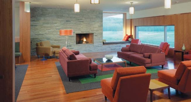 The men's grill is subdivided by columns and a media wall into a series of public spaces and more private ones, such as this seating area in front of a fireplace. Strategically positioned windows provide views into nature and over the greens.