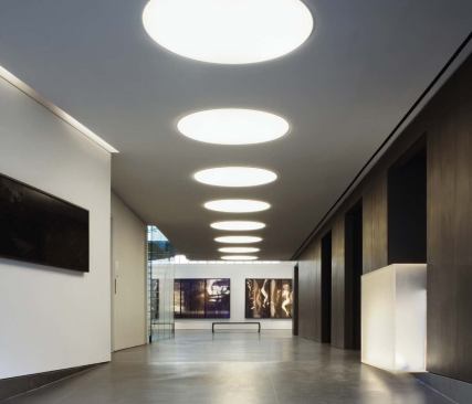 A 60-foot-long, dark anthrax-zinc wall leads visitors from the street to a double-height gallery at the rear of the building. 