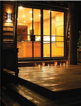 A tree grows in San Antonio: Just outside the glass wall and capping the kitchen at due north, an existing oak shades a new deck. Elongated steps wrap around the opposite corner, leading guests beyond the tree branches to a protected brick patio.