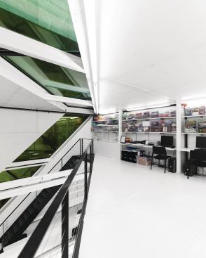 The floor of the second-level loft is formed from corrugated Cor-Ten steel, and was constructed as part of the container modification process. The loft is accessed via a narrow stair, which passes in front of the custom glazing that cuts through the container surface. The studio is cooled with a dual-zone, split system HVAC from Mitsubishi Electric, which uses different fan-coil units for each level.