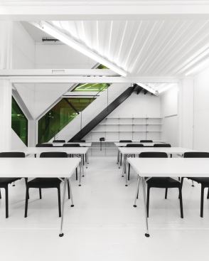 Inside the studio, the walls and ceiling are clad in panels from Push Design, and the ground-floor art studio is outfitted with Vitra tables and Knoll chairs; the space is lit by Legion Lighting Co. fixtures, which are connected by Lutron Electronics Co. controls.