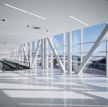 Passengers arriving at JFK via the city-encouraged AirTrain access the new T5 via a skybridge, which offers views of the Saarinen TWA terminal from moving walkways. 