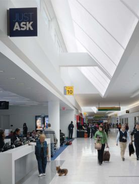 The concourses are peppered with information stations and concessions. White walls and light-colored flooring allow JetBlue’s signature blue and other accent colors to pop.