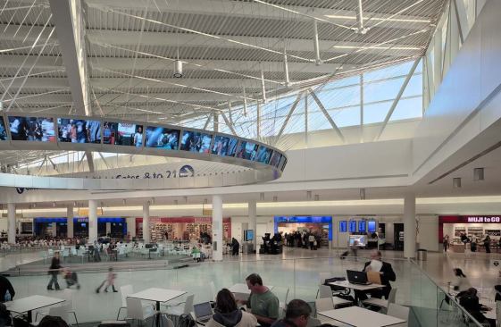The Marketplace, located just past the security area, serves as the central concessions area. The three concourses branch off it. Restaurants and stores, a performance venue, and a suspended, egg-shaped “information yoke” dominate the space.