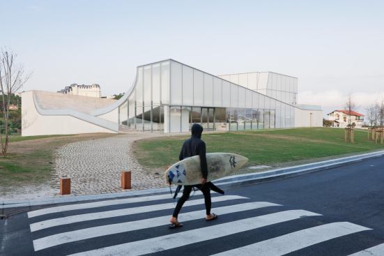 A surfer walks past the entrance on the northeast corner