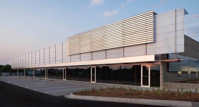 At Monarch Place, Brown tailored his design to a smaller budget, dictated by lower rental rates. Gone are the angles of 120 Blondo and the copper of Village Pointe East. Instead, a screen of inexpensive metal studs gestures to the wooden barns prevalent in the Midwest.