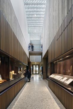 A double-height corridor is lined with glass display cases.