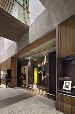 Canvases are stored on vertical racks in a light-controlled space that is visible to the public.