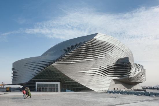 Louvers in the skin expose the glass envelope underneath, while allowing daylight to penetrate public spaces and airflow to naturally ventilate the building.