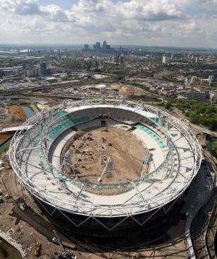 Aerial view of Olympic Stadium during construction. The cable-net roof structure comprises an outer compression truss and an inner tension ring.