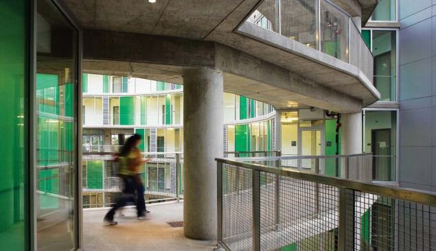 A dominant visual feature of the 63 student apartments is colored glazing, an insulating spandrel glass manufactured by Viracon. The white, gray, and green colors are applied with a ceramic frit. Concrete balconies and walkways provide basic circulation as well as vantage points for watching outdoor performances.