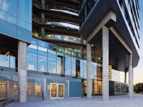 The recessed first and second floors contain many of the building's public functions, including the lobby, theater, and café. Sixteen different types of glass are used in the building. The character of the glazing gives a clue to the spaces within: clear glass for public spaces; fritted glass allowing sightlines into the studio spaces, but a modicum of privacy; and more-opaque, colored glass in the residential areas.