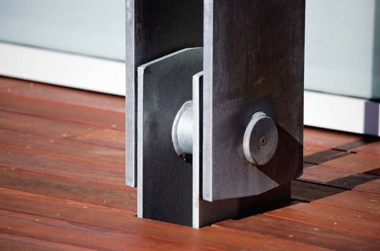 A steel anchor is set into the building foundation and is connected to the steel louver supports with a steel pin, ensuring that the louvers are secure, even in high winds.
