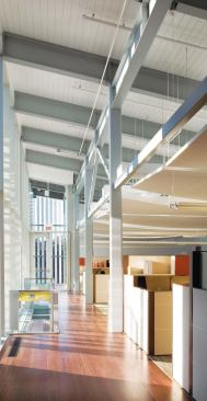 On the second floor, high ceilings and floor-to-ceiling windows afford views of the outdoors, one benefit of going through the site-remediation process. Despite the cost of the cleanup, as well as the rich hardwood detailing throughout the building, the cost was a modest $220 per square foot-or $80 below comparable area projects.