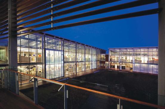 To keep with the overall Cape Cod aesthetic, the design team split the needed 55,000 square feet into three connected buildings in a horseshoe configuration. Expansive glazing allows for views onto the meadow landscape created by Stephen Stimson Associates and lets workers in the open office spaces see into each of the other buildings. Stationary wood louvers help to block glare, and an exterior boardwalk around the perimeter of the courtyard provides circulation during the warmer months.