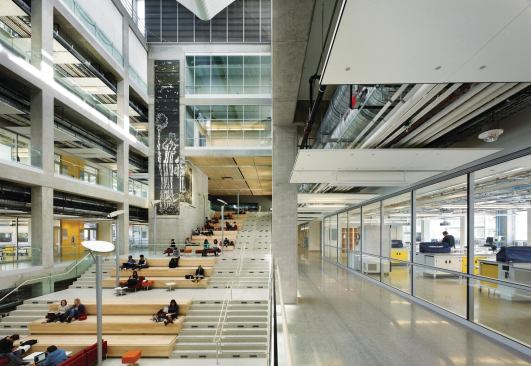 Glazed walls allow students sitting on the stairs to see into the laboratories and classrooms on the upper floors and out to the street beyond. The building “is the size of a football field, but you can stand anywhere and see outside,” project manager-designer Rick Piccolo says.