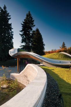 Outlined with a border of gravel to allow drainage, the green roof serves as its own ecosystem—playing host to a variety of plant species—and it dips down to grade level to allow access to local fauna.