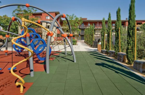 The playground includes a play structure and rubberized play tiles with recycled content.