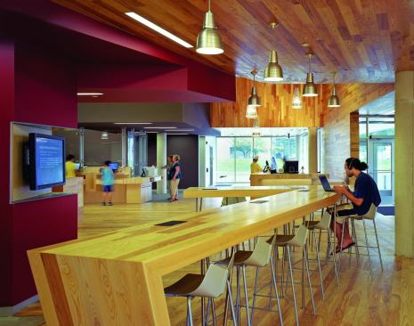 Technology is omnipresent in the library. Visitors can search for titles at computer terminals at the information desk, and video screens mounted near the entrance display library events and information. Touchdown space for those using their personal computers for work or research is provided in the form of wood tables with inset power management.