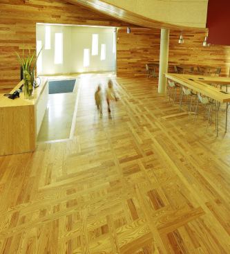 Wood is the predominant finish in the lobby, making up the floor, walls, under-soffit ceiling, and most of the furniture. In addition to telling a local story and adding to the sustainability agenda, the material is durable and can withstand the high foot traffic, and the variegated color of the planks on the walls will hide the inevitable wear and tear on the building.